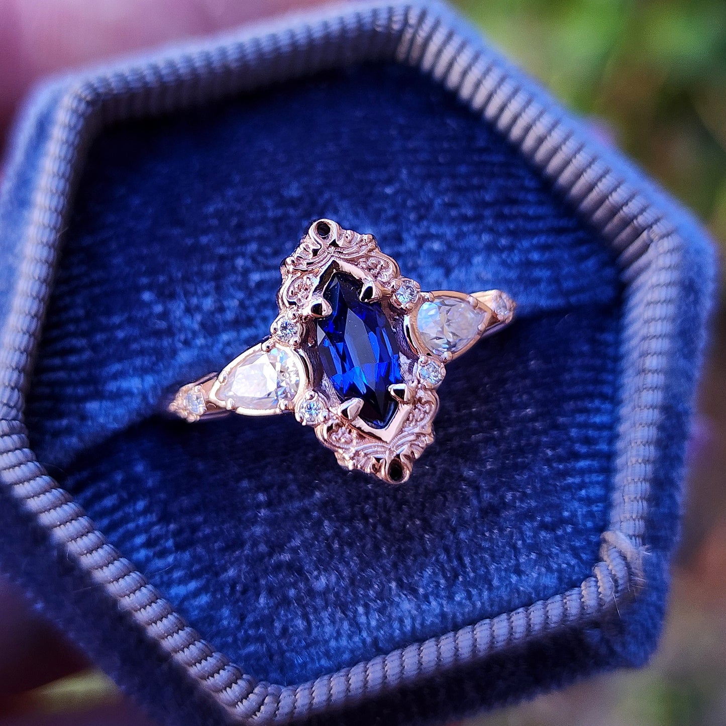 Rose gold filigree ring with a blue sapphire marquise gemstone in a blue velvet box image 3