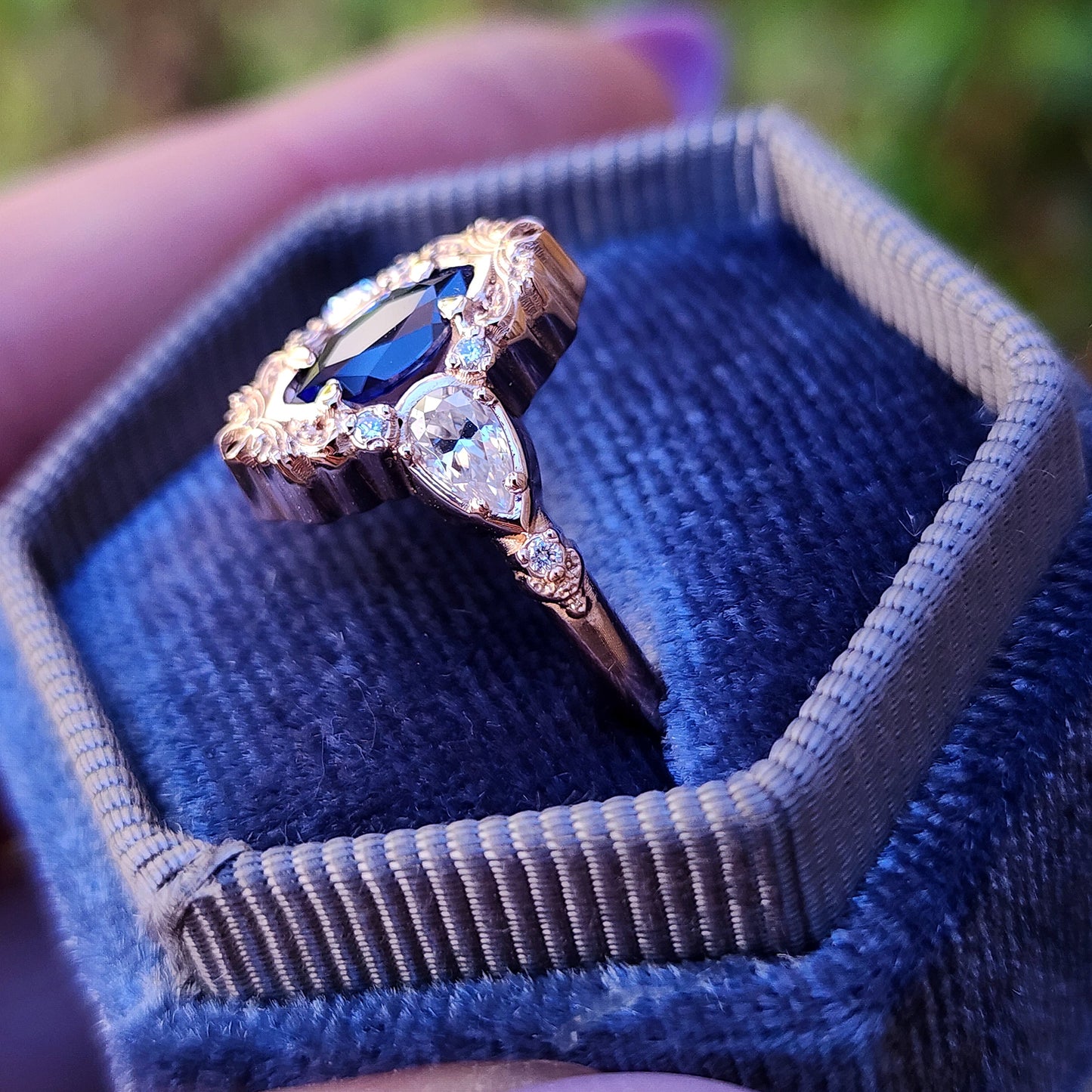 Rose gold filigree ring with a blue sapphire marquise gemstone in a blue velvet box image 6
