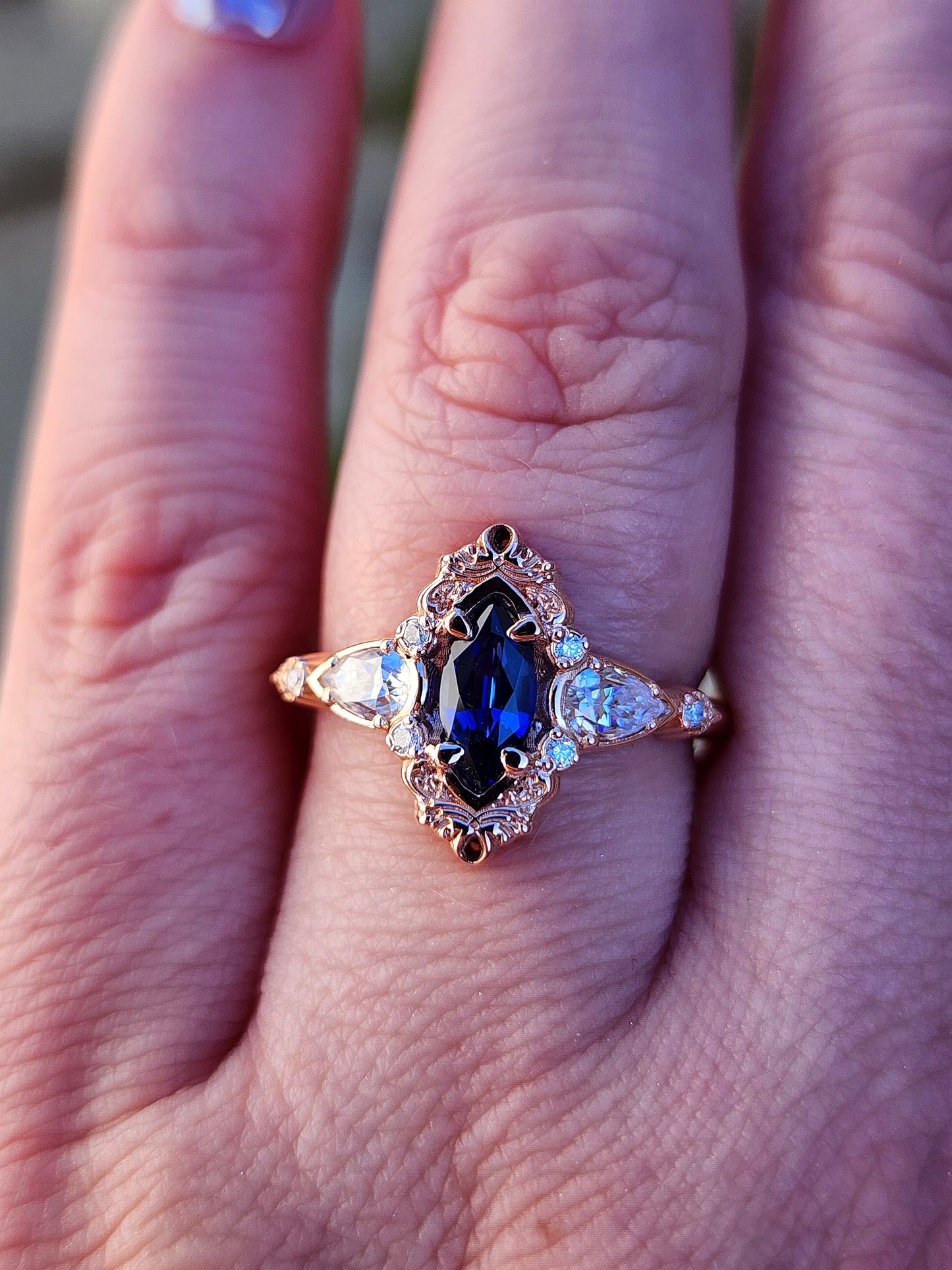 Rose gold filigree ring with a blue sapphire marquise gemstone in a blue velvet box image 9