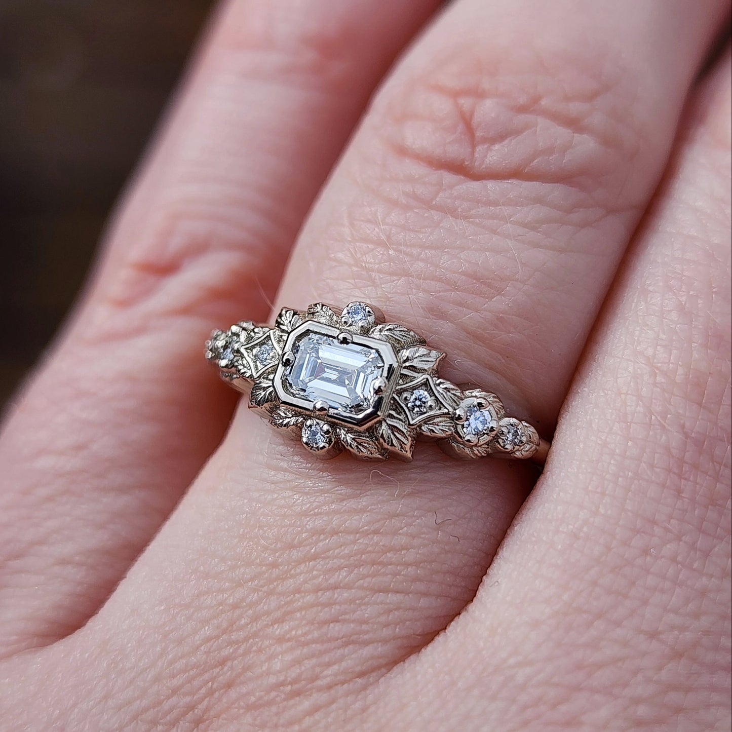 nature-inspired ring , featuring a .32 carat natural emerald-cut diamond set in an east-west orientation. The delicate leaf motif is crafted in 14kt palladium white gold image 9