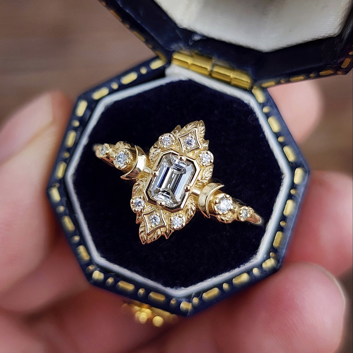 Elegant, and nature-inspired design, this ring features a delicate leaf motif and crescent moons, all crafted in 14kt yellow gold The center stone is a .30 carat natural emerald-cut diamond image 3