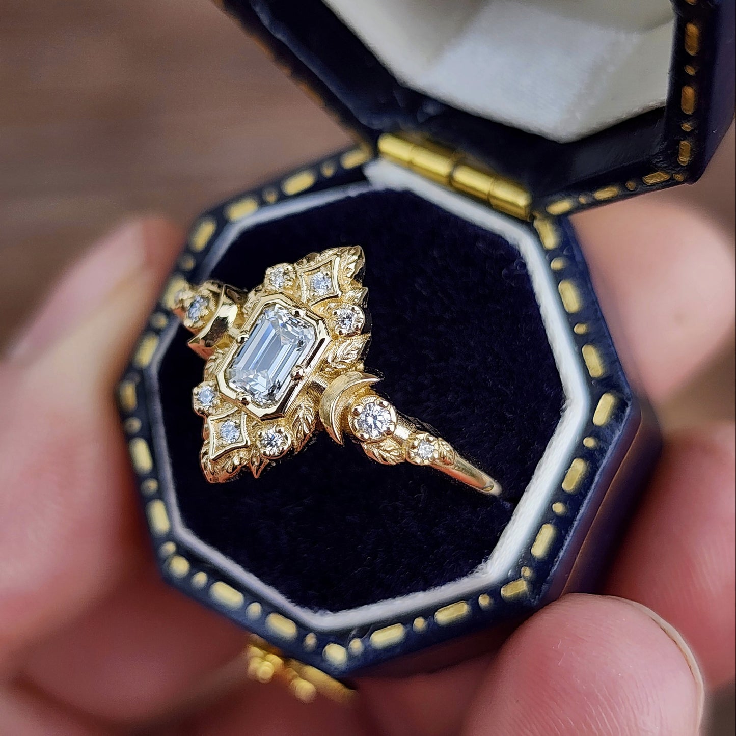 Elegant, and nature-inspired design, this ring features a delicate leaf motif and crescent moons, all crafted in 14kt yellow gold The center stone is a .30 carat natural emerald-cut diamond image 4