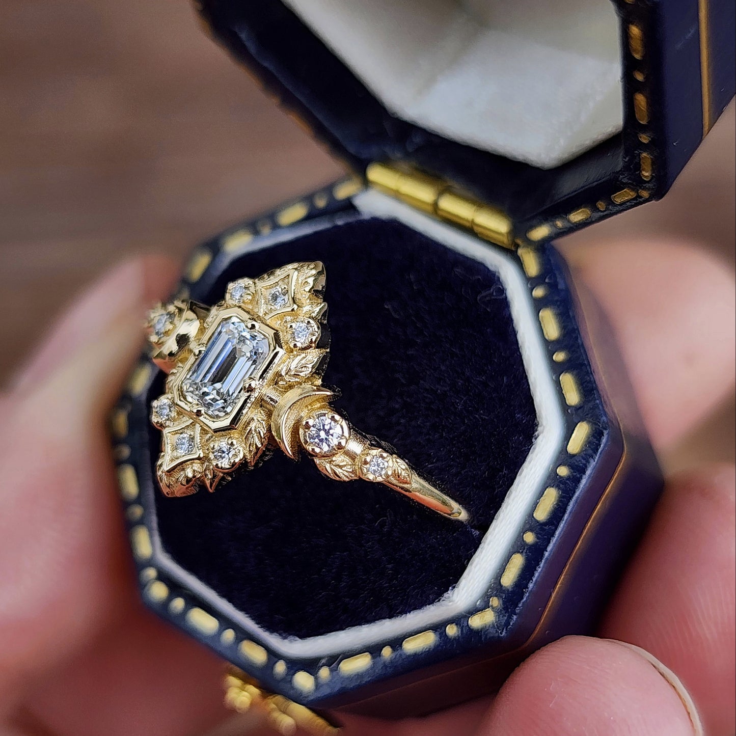 Elegant, and nature-inspired design, this ring features a delicate leaf motif and crescent moons, all crafted in 14kt yellow gold The center stone is a .30 carat natural emerald-cut diamond image 5