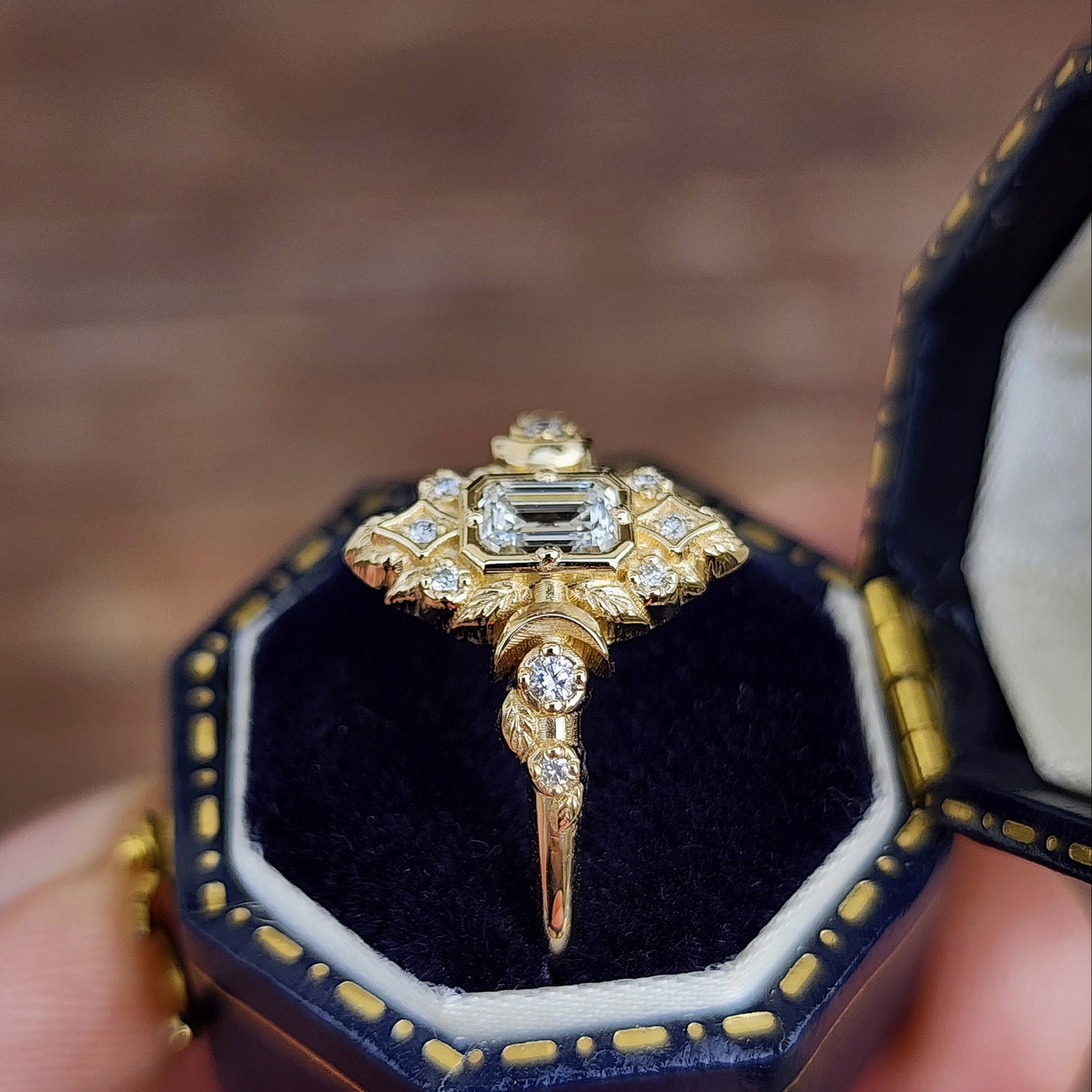 Elegant, and nature-inspired design, this ring features a delicate leaf motif and crescent moons, all crafted in 14kt yellow gold The center stone is a .30 carat natural emerald-cut diamond image 6