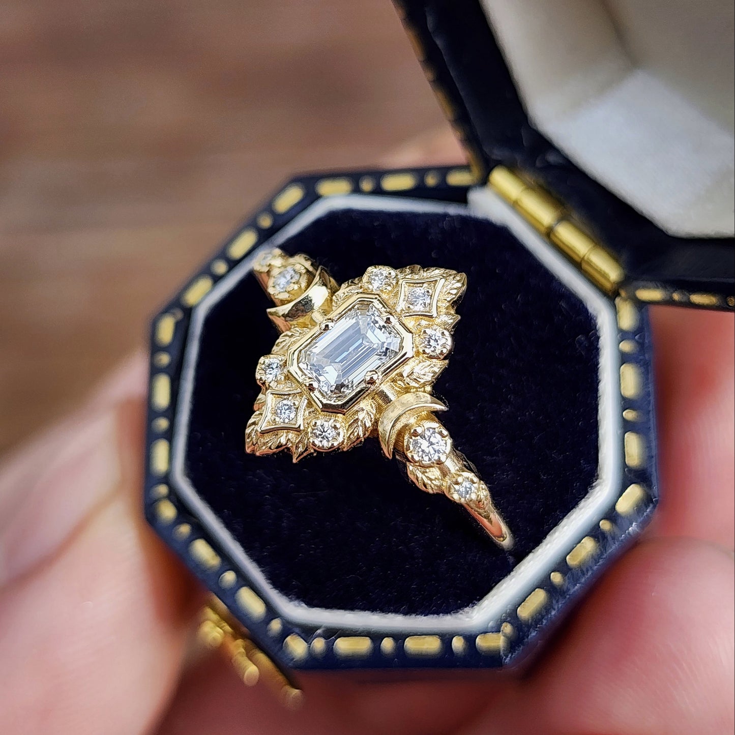 Elegant, and nature-inspired design, this ring features a delicate leaf motif and crescent moons, all crafted in 14kt yellow gold The center stone is a .30 carat natural emerald-cut diamond image 7