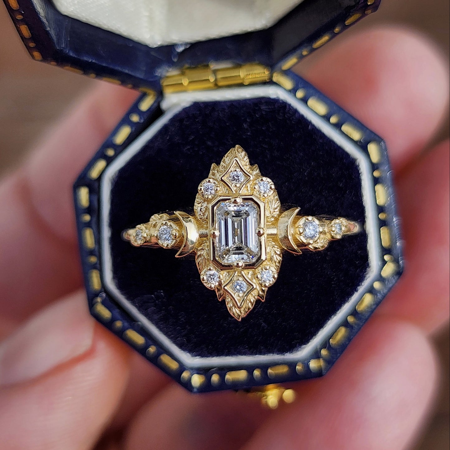 Elegant, and nature-inspired design, this ring features a delicate leaf motif and crescent moons, all crafted in 14kt yellow gold The center stone is a .30 carat natural emerald-cut diamond image 1