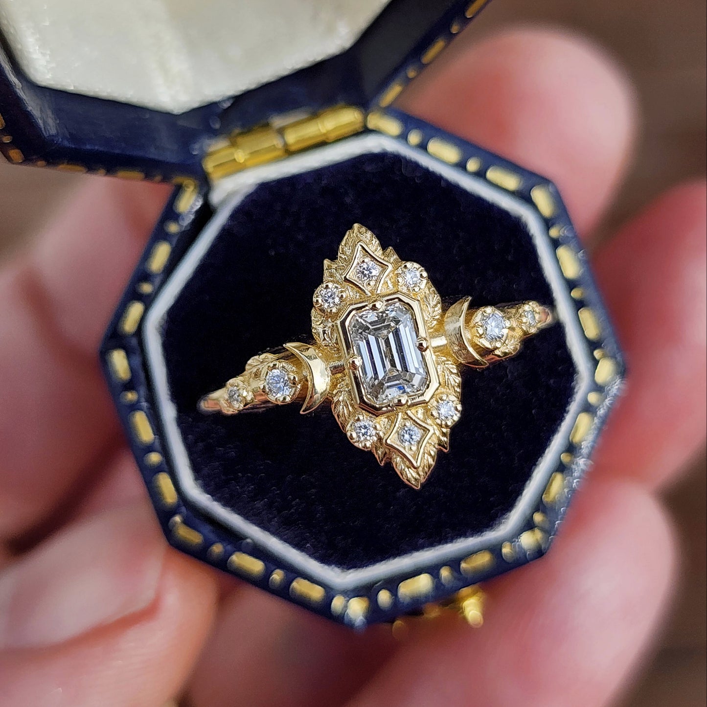 Elegant, and nature-inspired design, this ring features a delicate leaf motif and crescent moons, all crafted in 14kt yellow gold The center stone is a .30 carat natural emerald-cut diamond image 2