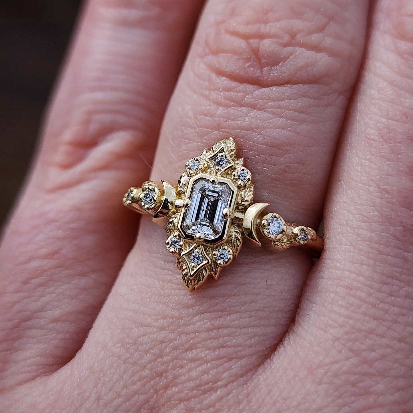 Elegant, and nature-inspired design, this ring features a delicate leaf motif and crescent moons, all crafted in 14kt yellow gold The center stone is a .30 carat natural emerald-cut diamond image 10