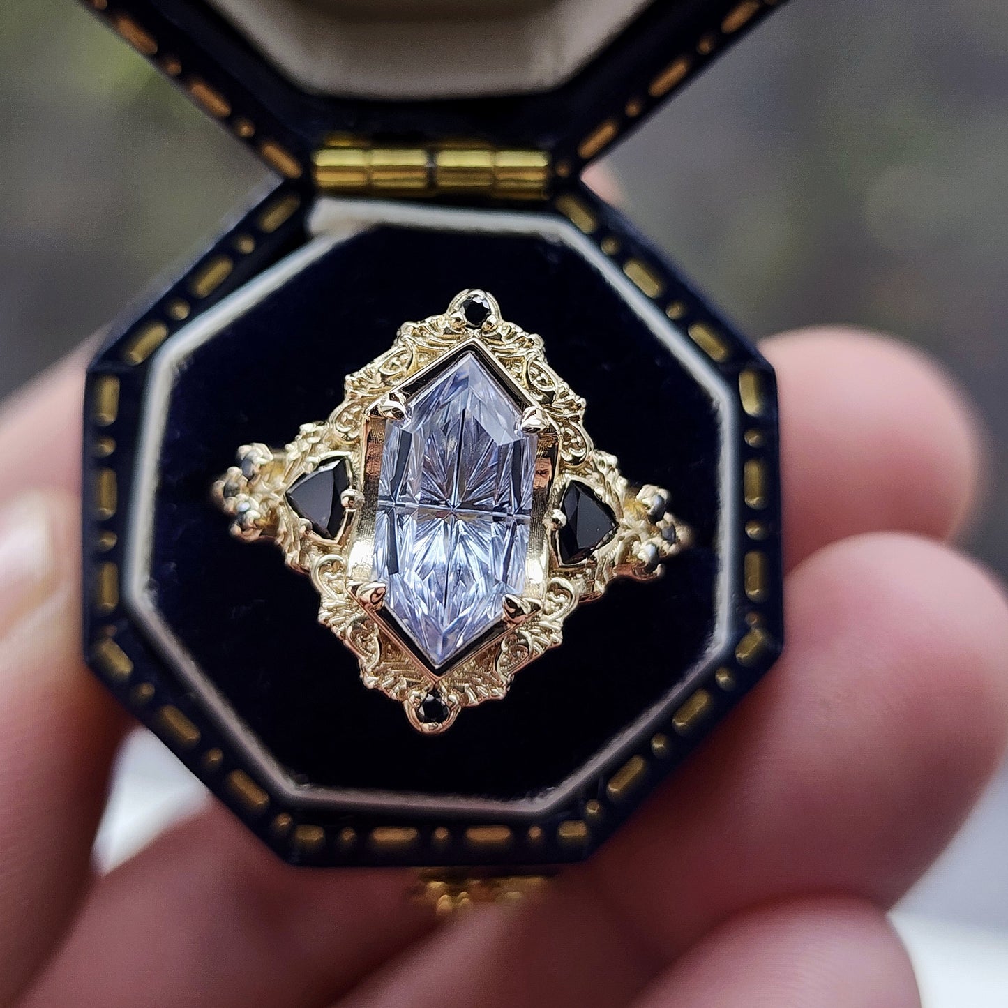 Ophelia/Delilah hybrid ring features a 2.92ct Light Purple Lab Sapphire Fantasy Cut from Fellowship Forge. The ring is accented with black diamond trillions totaling .18cts and additional black diamond accent stones totaling .07cts Crafted in 14kt yellow gold image 3