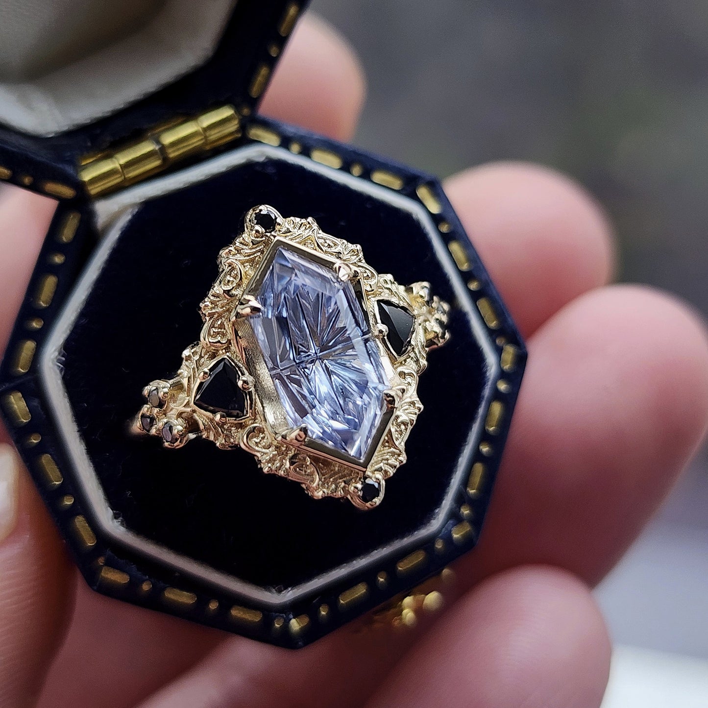 Ophelia/Delilah hybrid ring features a 2.92ct Light Purple Lab Sapphire Fantasy Cut from Fellowship Forge. The ring is accented with black diamond trillions totaling .18cts and additional black diamond accent stones totaling .07cts Crafted in 14kt yellow gold image 5