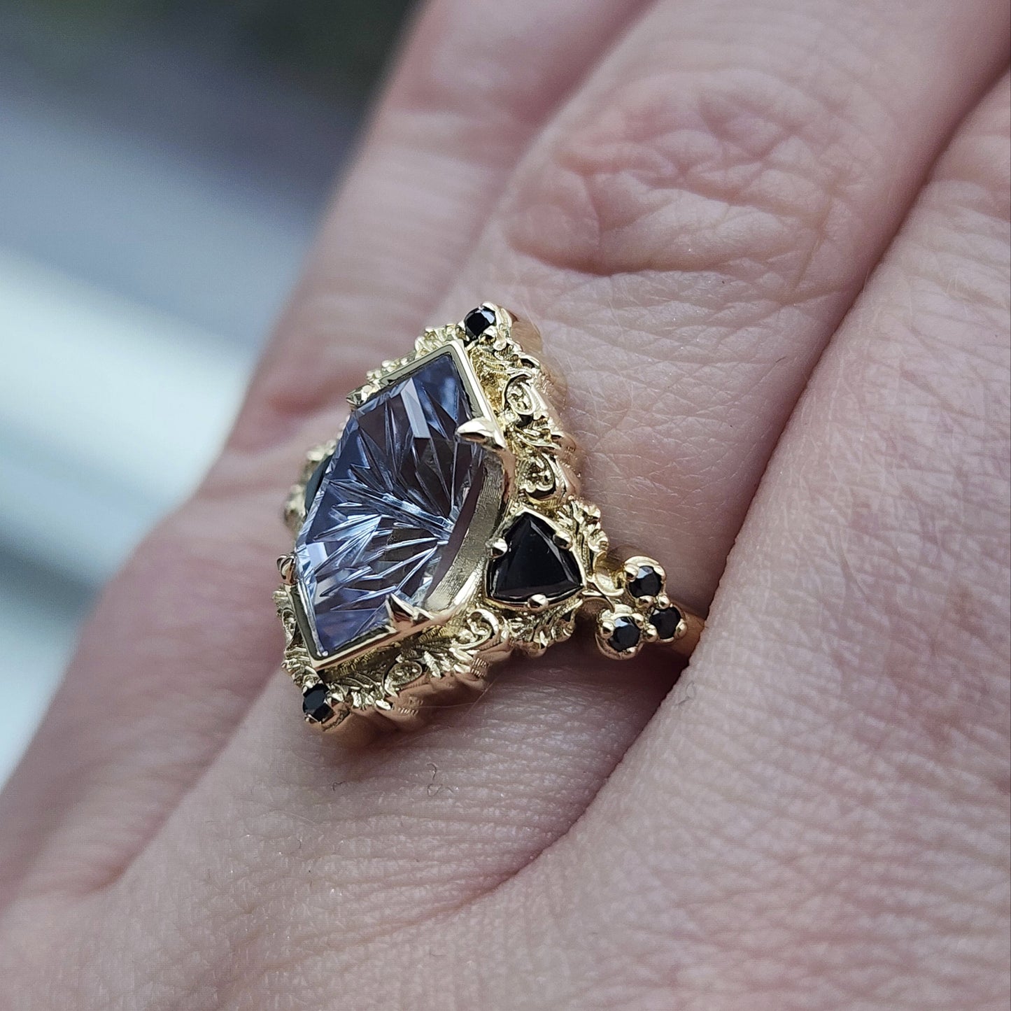 Ophelia/Delilah hybrid ring features a 2.92ct Light Purple Lab Sapphire Duchess Fantasy Cut from Fellowship Forge. The ring is accented with black diamond trillions totaling .18cts and additional black diamond accent stones totaling .07cts Crafted in 14kt yellow gold image 8