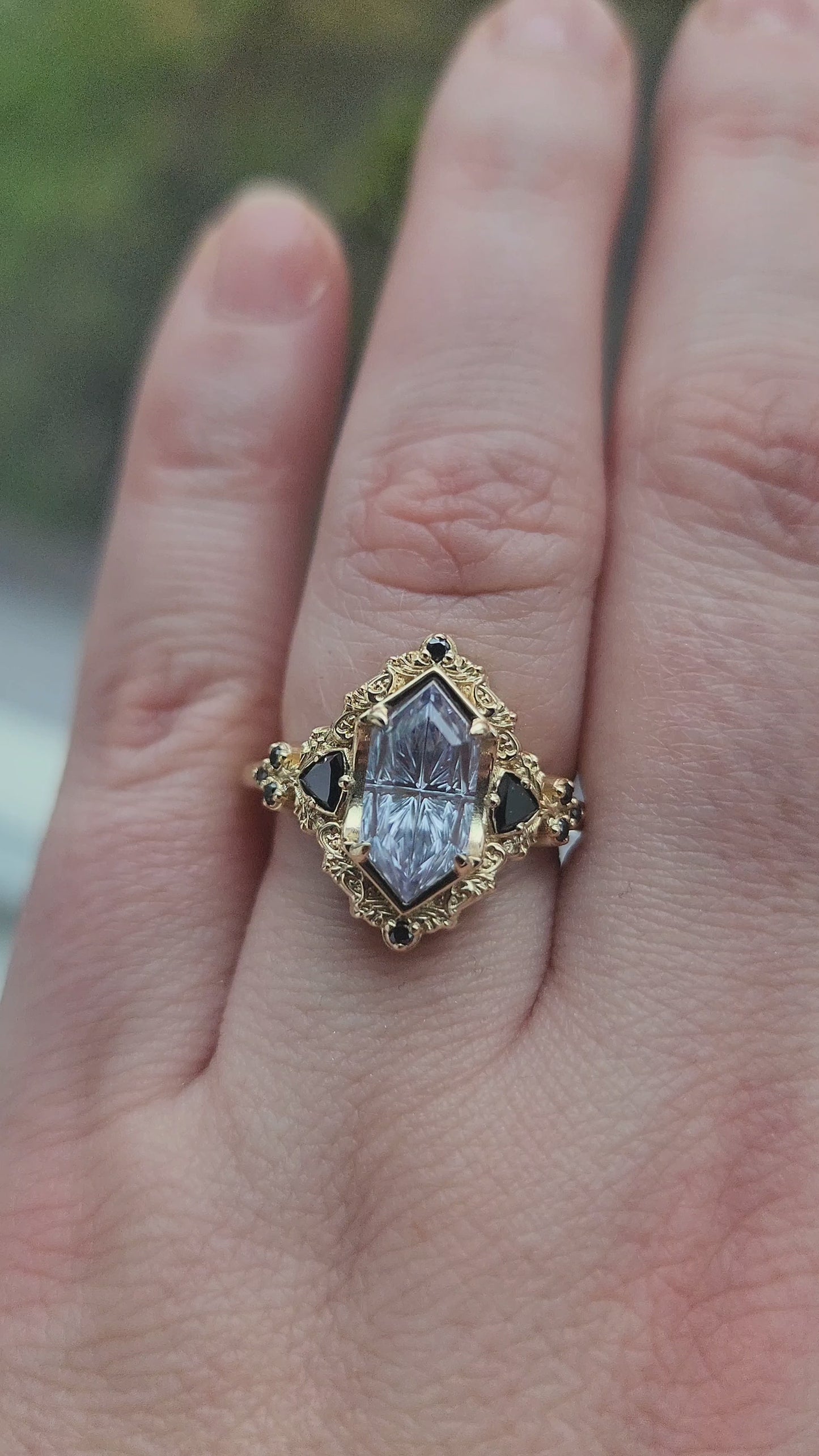 Load and play video in Gallery viewer, Ophelia/Delilah hybrid ring features a 2.92ct Light Purple Lab Sapphire Duchess Fantasy Cut from Fellowship Forge. The ring is accented with black diamond trillions totaling .18cts and additional black diamond accent stones totaling .07cts Crafted in 14kt yellow gold video 1
