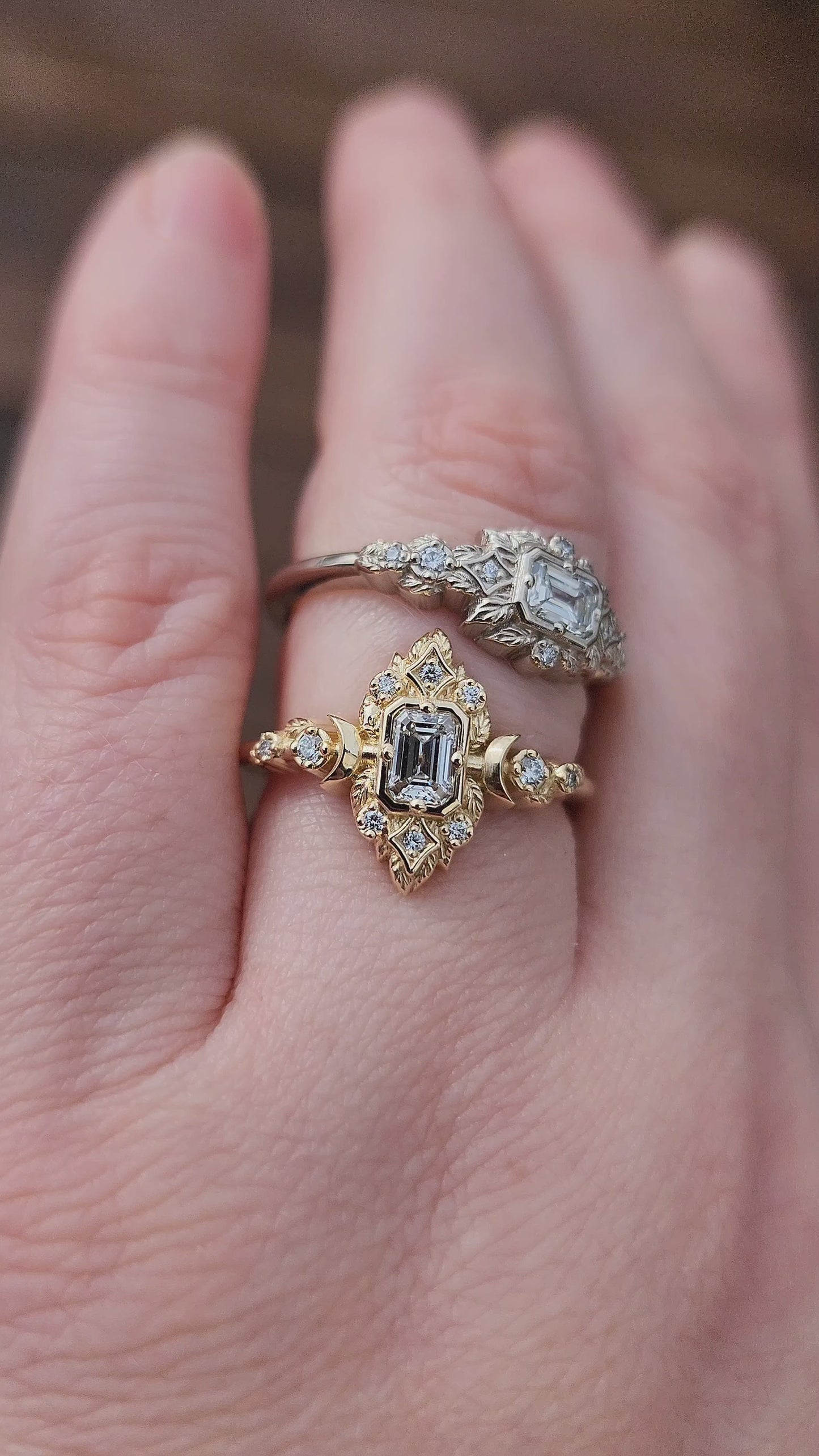 Load and play video in Gallery viewer, Elegant, and nature-inspired design, this ring features a delicate leaf motif and crescent moons, all crafted in 14kt yellow gold The center stone is a .30 carat natural emerald-cut diamond video 2
